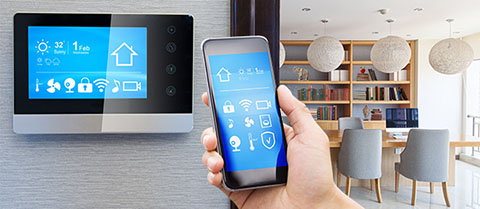 A hand with remote pointing at a wall panel